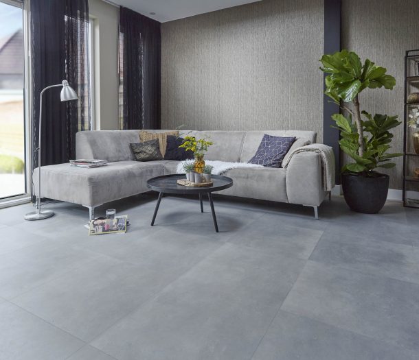 Woonkamer in natuurlijke stijl met Wijs tegel pvc-vloer, zandkleurig structuurbehang en moderne hoekbank. Woonkamer in natuurlijke stijl met Wijs tegel pvc-vloer, zandkleurig structuurbehang en moderne hoekbank.