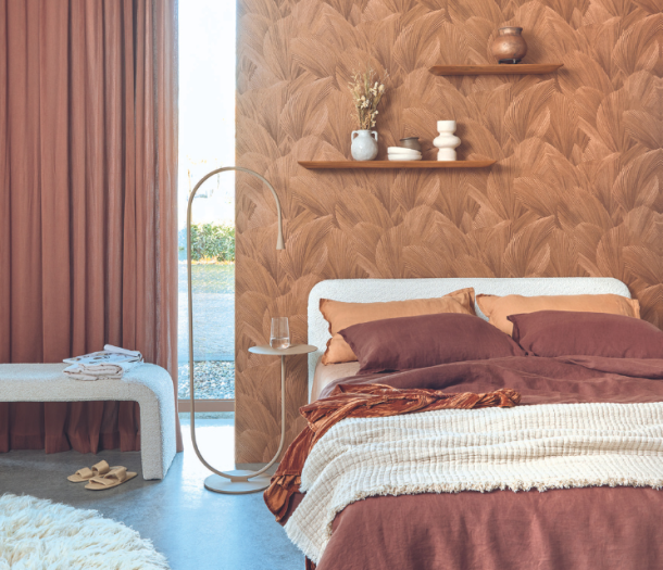 Behang achter het bed met bruine bladeren