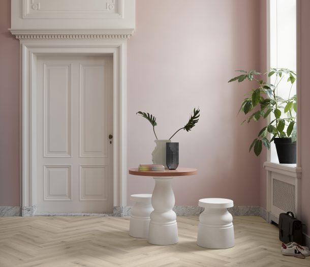 Kamer in klassieke stijl met poederroze muren, WIJS visgraat vloer, marmerlook plinten en houten kozijnen en deuren.