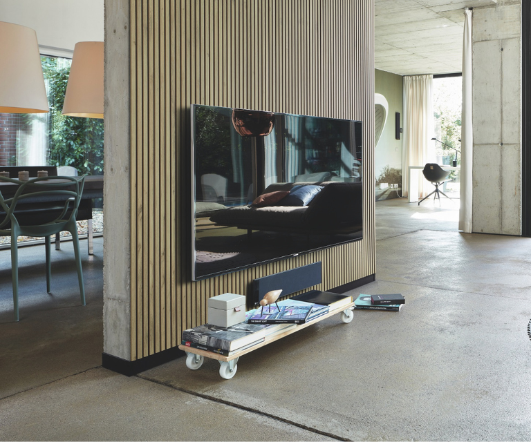 Licht houten wandpanelen achter de tv in de woonkamer