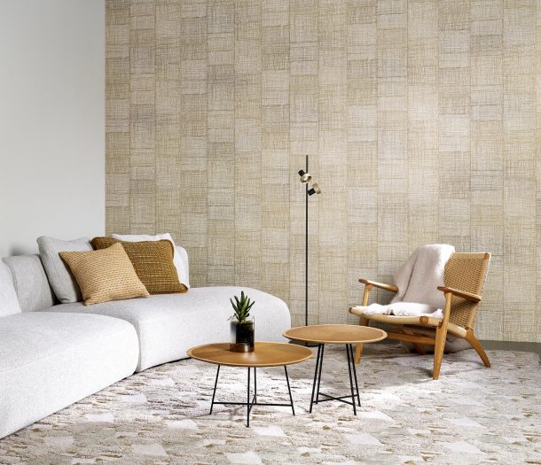 Woonkamer met witte loungebank, ronde salontafeltjes, zandkleurig behang met subtiel patroon