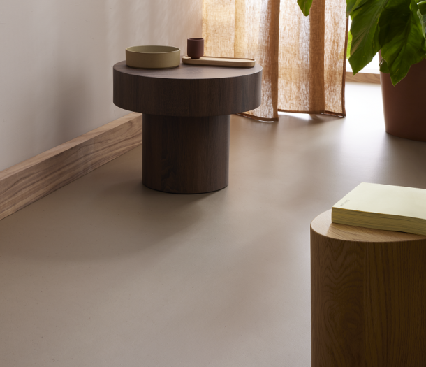 Detail marmoleum vloer in warme cacao tint en hoge plinten houtlook