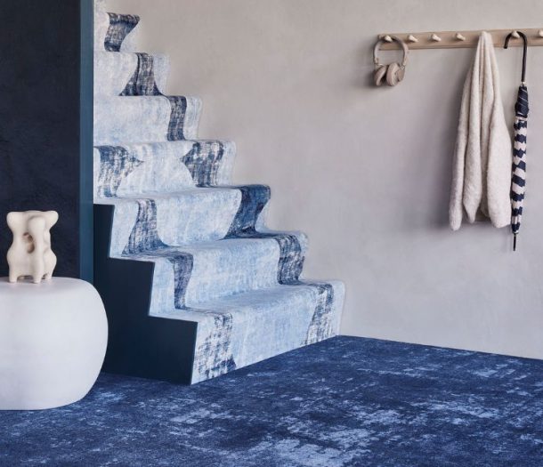 Donker blauw tapijt op de vloer en lichtblauw tapijt op de trap