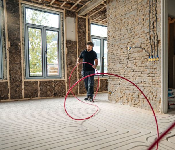 Vakman die ingefreesde vloerverwarming legt in sleuven