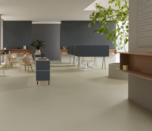 Kantoorruimte in industriele stijl met houten stoelen, flexplekken en lichtgroene marmoleum vloer