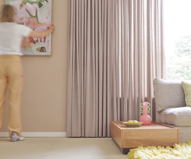 Bohemian woonstijl detail roze gordijnen en hoogpolig geel vloerkleed