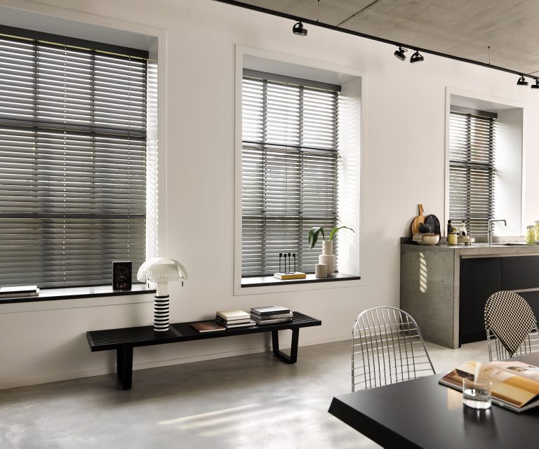 Industriele stijl woonkamer met zwarte meubelen en zwarte houten jaloezien