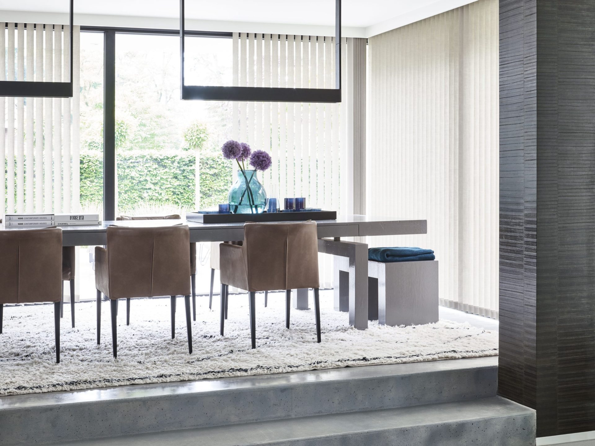 Industriele stijl eetkamer met betonlook vloer en robuuste tafel, lamellen als raamdecoratie