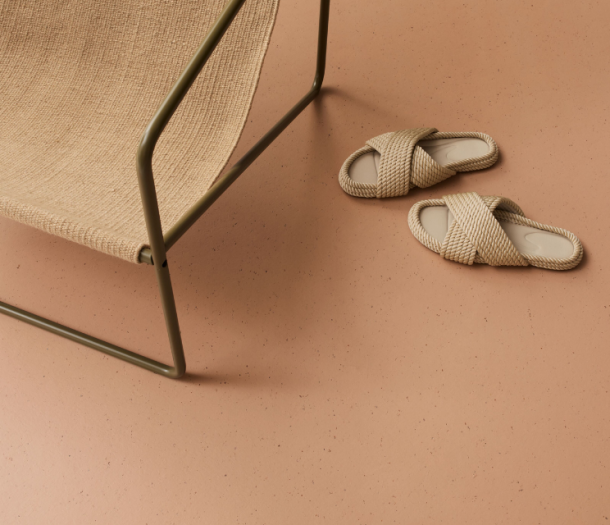 Licht terracotta marmoleumvloer met stoel en slippers