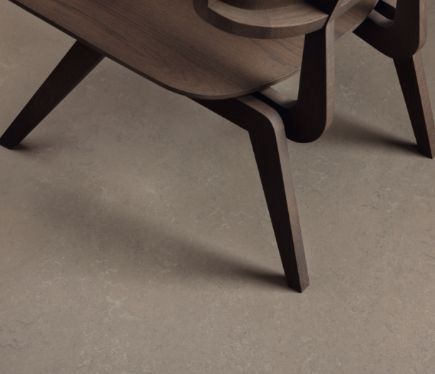 Grijz/bruin marmoleum vloer met donker bruine stoel