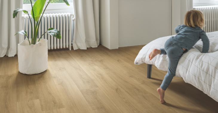 Warme, naturel eiken laminaatvloer in de slaapkamer met kind