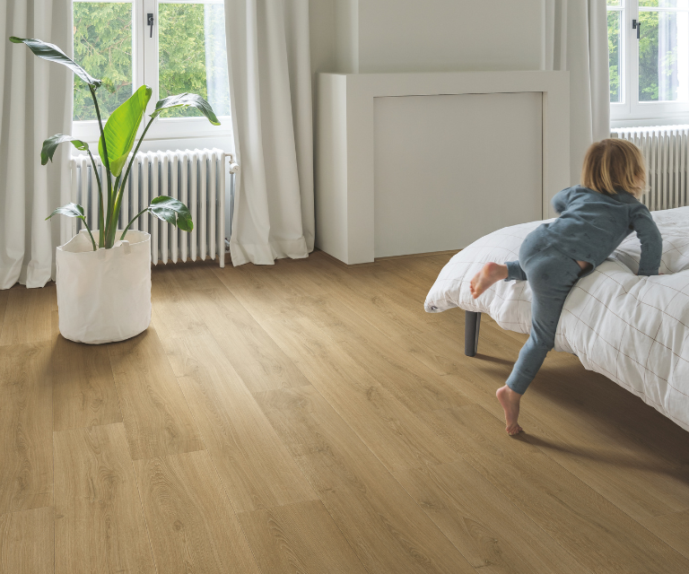 Warme, naturel eiken laminaatvloer in de slaapkamer met kind