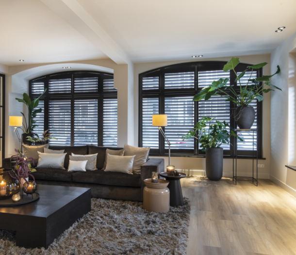 Zwarte shutters met halfronde ramen in de woonkamer