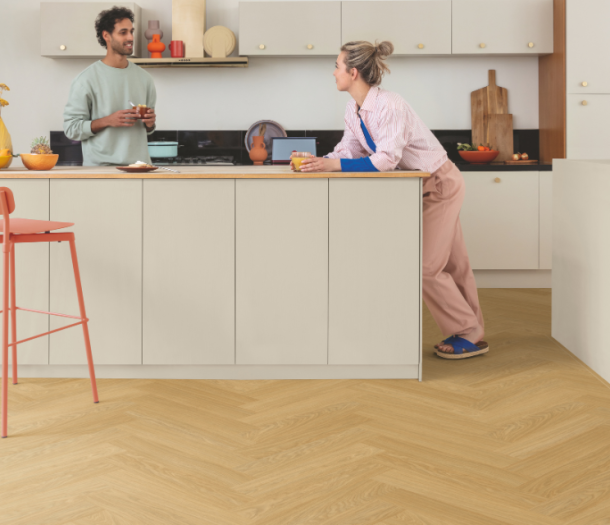 2 mensen in de keuken met een lichte houtlook visgraatvloer