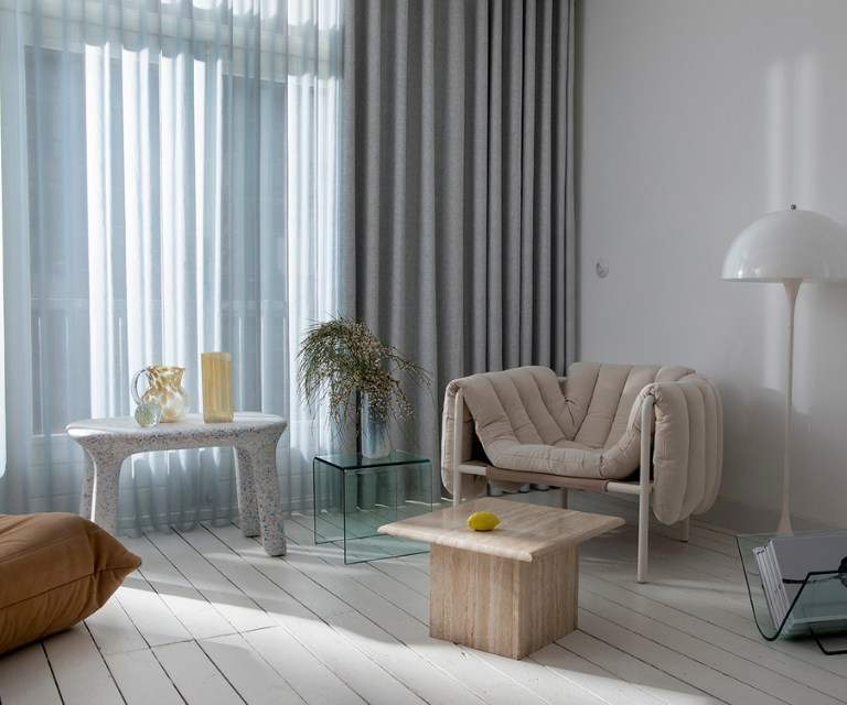 Licht blauwe vitrages met grijze overgordijnen in de zithoek