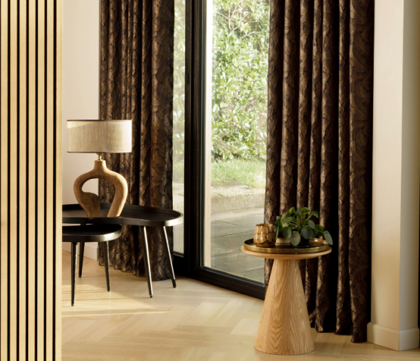 Donker bruine overgordijnen met lichte bladeren in een klassieke woning