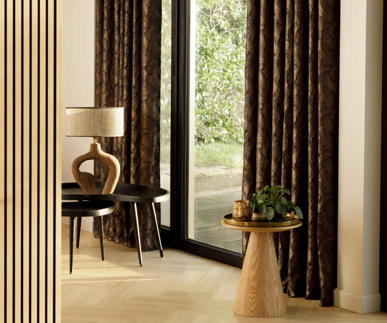 Donker bruine overgordijnen met lichte bladeren in een klassieke woning