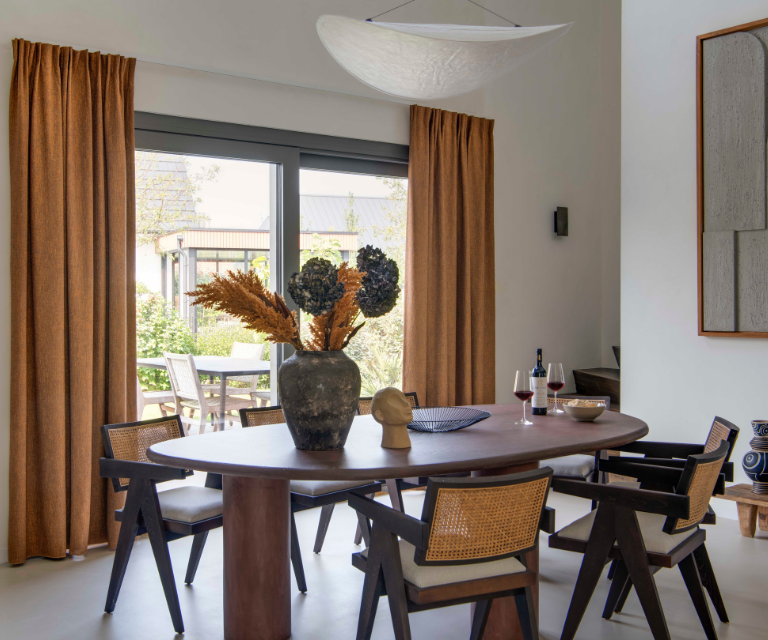 Bruine overgordijnen in een japandi eetkamer met schuifpui