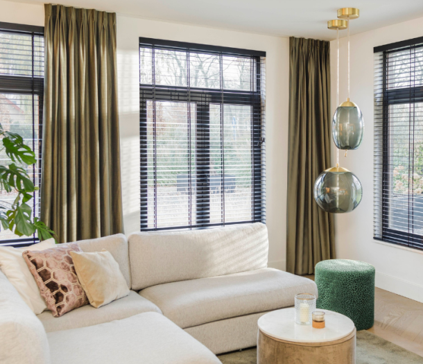 Donker groene gordijnen en zwarte jaloezieën in een hotel chic woonkamer Donker groene gordijnen en zwarte jaloezieën in een hotel chic woonkamer