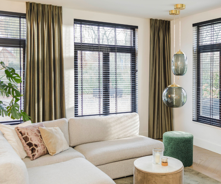 Donker groene gordijnen en zwarte jaloezieën in een hotel chic woonkamer