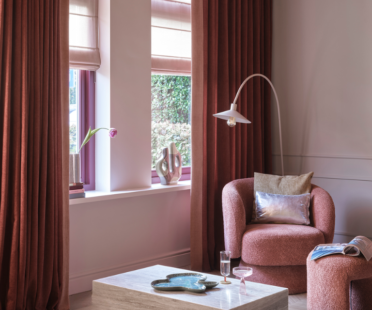 Donker rode overgordijnen en roze vouwgordijnen in de zithoek