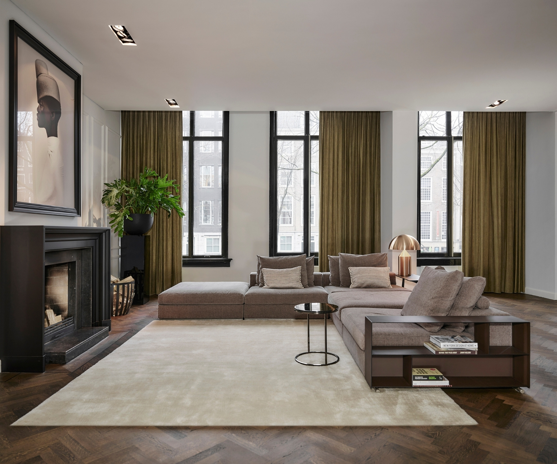 Groene overgordijnen in de woonkamer met grijze hoekbank, beige vloerkleed en donker bruine visgraatvloer Groene overgordijnen in de woonkamer met grijze hoekbank, beige vloerkleed en donker bruine visgraatvloer