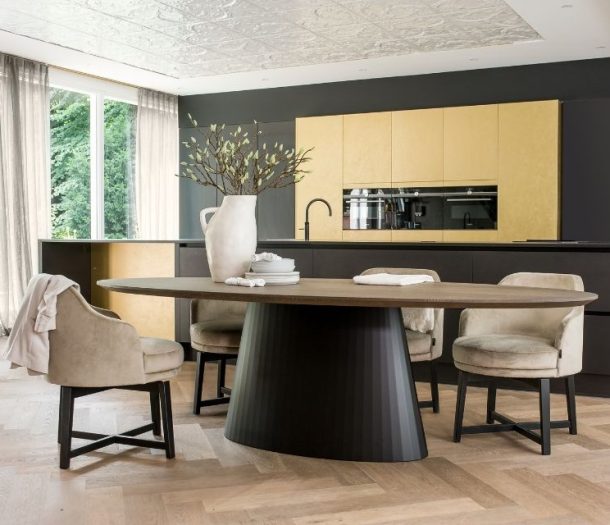 Ovaal ronde tafel met warm eiken blad en rond grote zwarte poot en lichte walvisgraatvloer