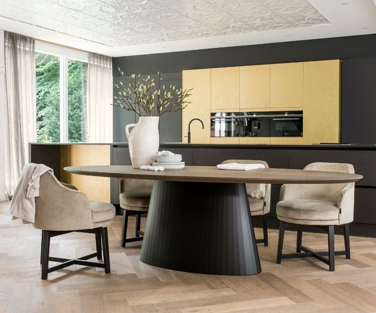 Ovaal ronde tafel met warm eiken blad en rond grote zwarte poot en lichte walvisgraatvloer