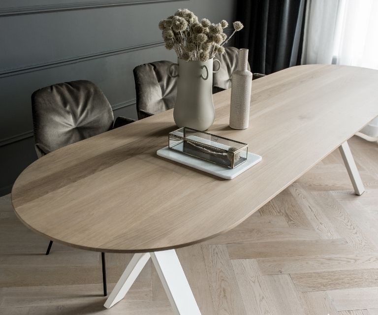 Lichte eiken tafel in halve cirkel vorm met lichte walvisgraat vloer