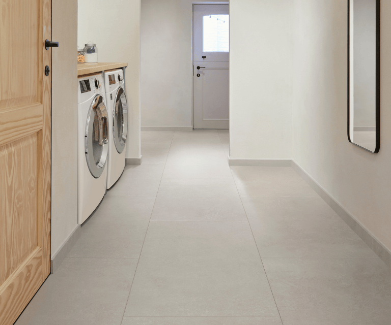 Licht grijze pvc-tegels in wasruimte met wasmachine en droger