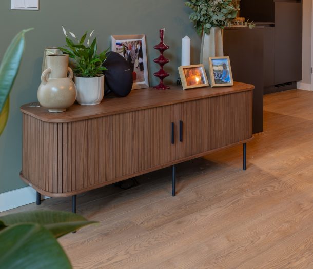 Woonkamer met dressoir en detail houtlook pvc vloer in warme bruintint