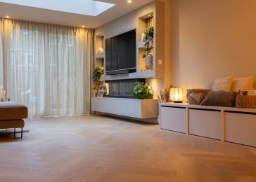 Woonkamer met kasten op maat en lichte visgraat pvc vloer