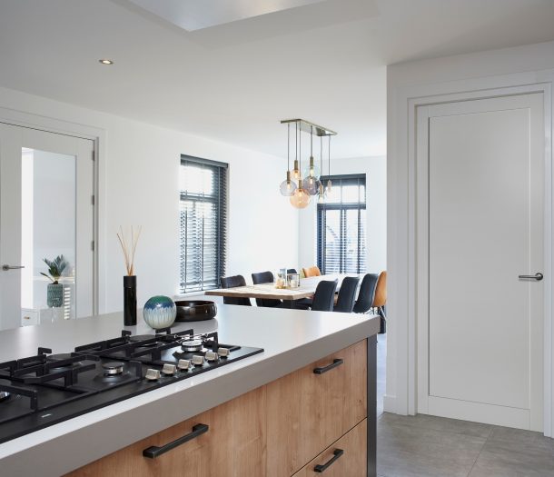 Witte binnendeur in keuken met chroom klink