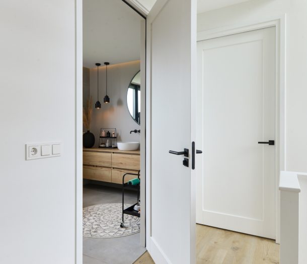 Witte binnendeuren met zwarte klink in badkamer en overloop