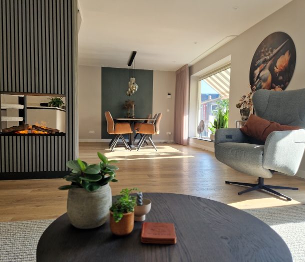 Moderne woonkamer eethoek met pruim inbetweens, houtlook pvc-vloer, groen behang, houten wandpanelen
