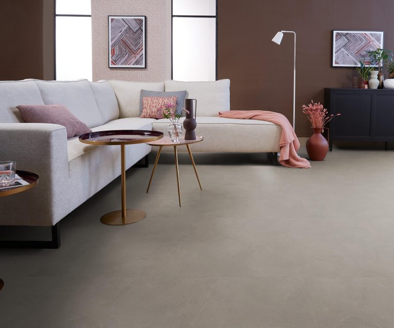 Woonkamer met witte bank en steenlook pvc-vloer in lichte grijstint