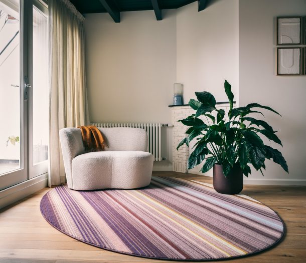woonkamer met loveseat en rond vloerkleed in nude tinten