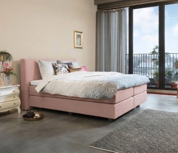 Slaapkamer met betonlook vloer en boxspring bed in de roze tint Blush