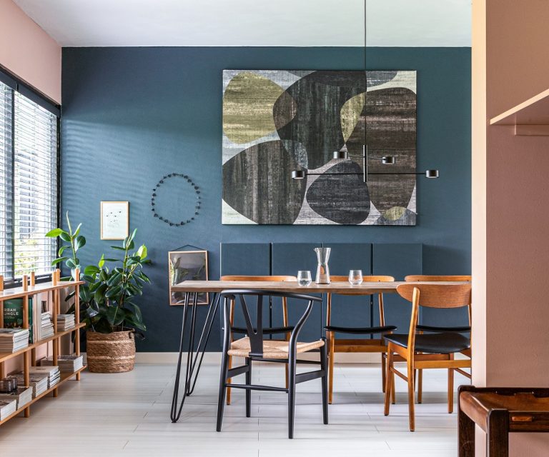 Eetkamer met ronde houten tafel en boucle stoelen tegen een muur in warm wit stucwerk van Pure & Original, met een nis vol decoratie.
